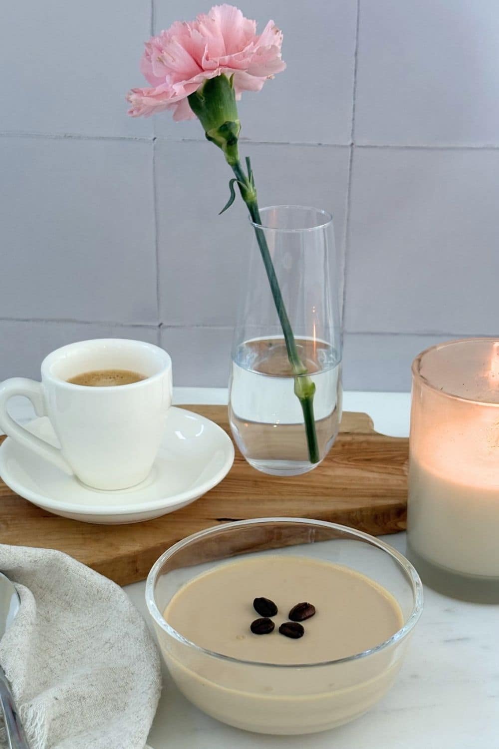 Ricotta and coffee cream dessert served with espresso, candlelight, and a pink flower beside the bowl.