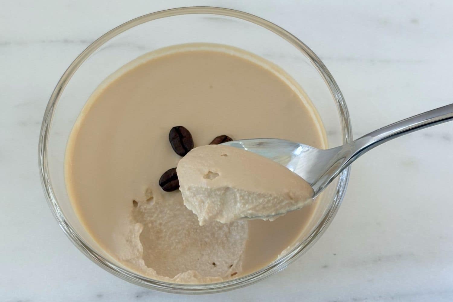 Spoonful of chilled ricotta and coffee cream dessert showing the smooth, mousse-like texture.