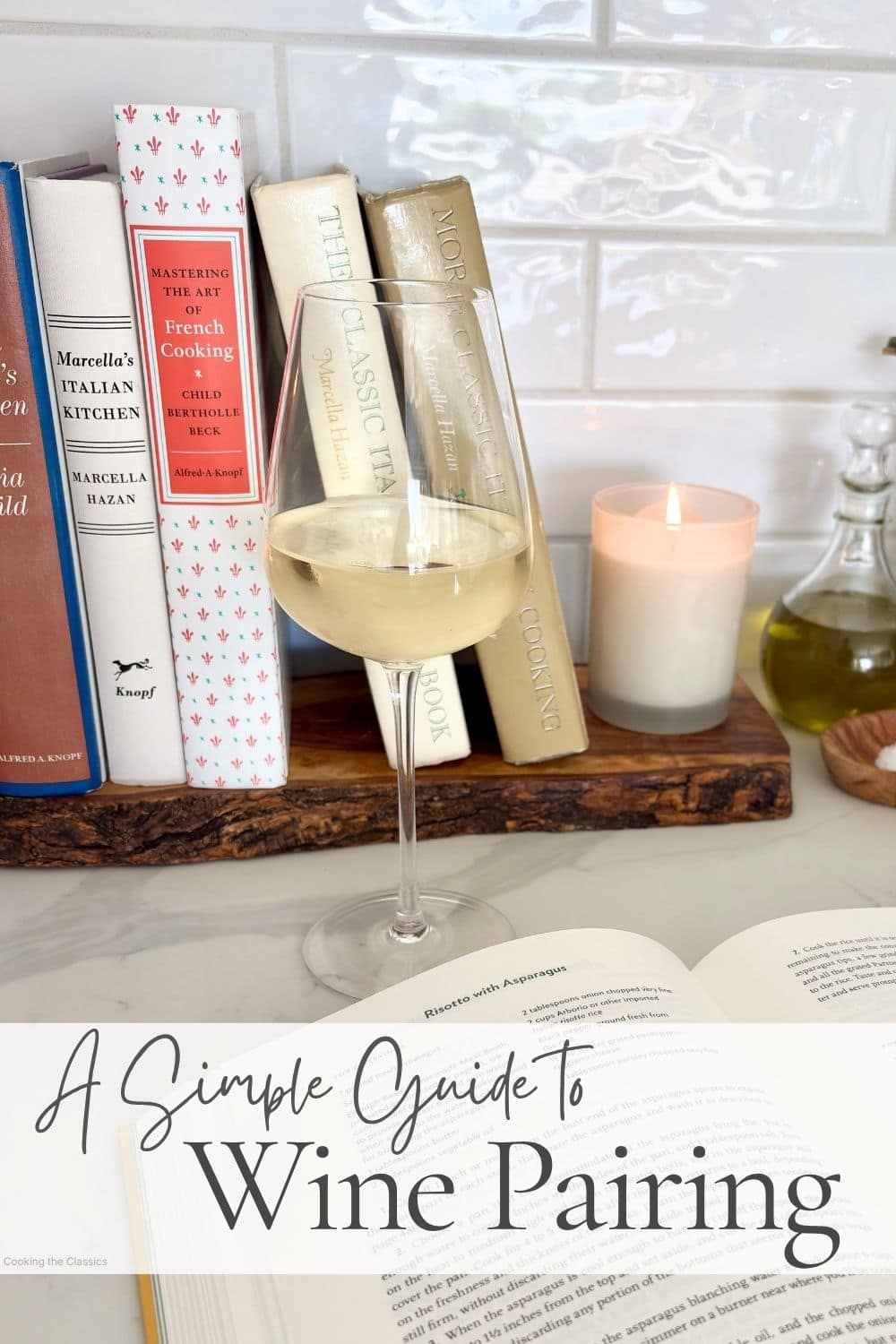 A glass of white wine on a kitchen counter in front of Italian and French cookbooks with text that says A Simple Guide to Wine Pairing.