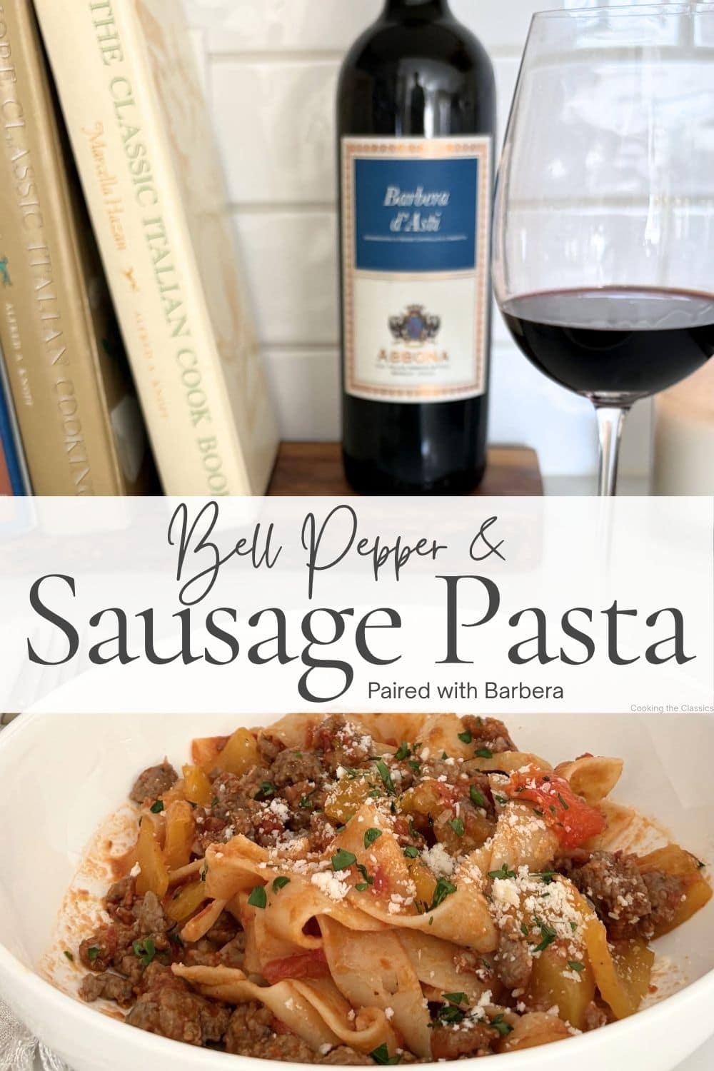 Bell pepper and sausage pasta served with a glass of red wine and cookbook in the background