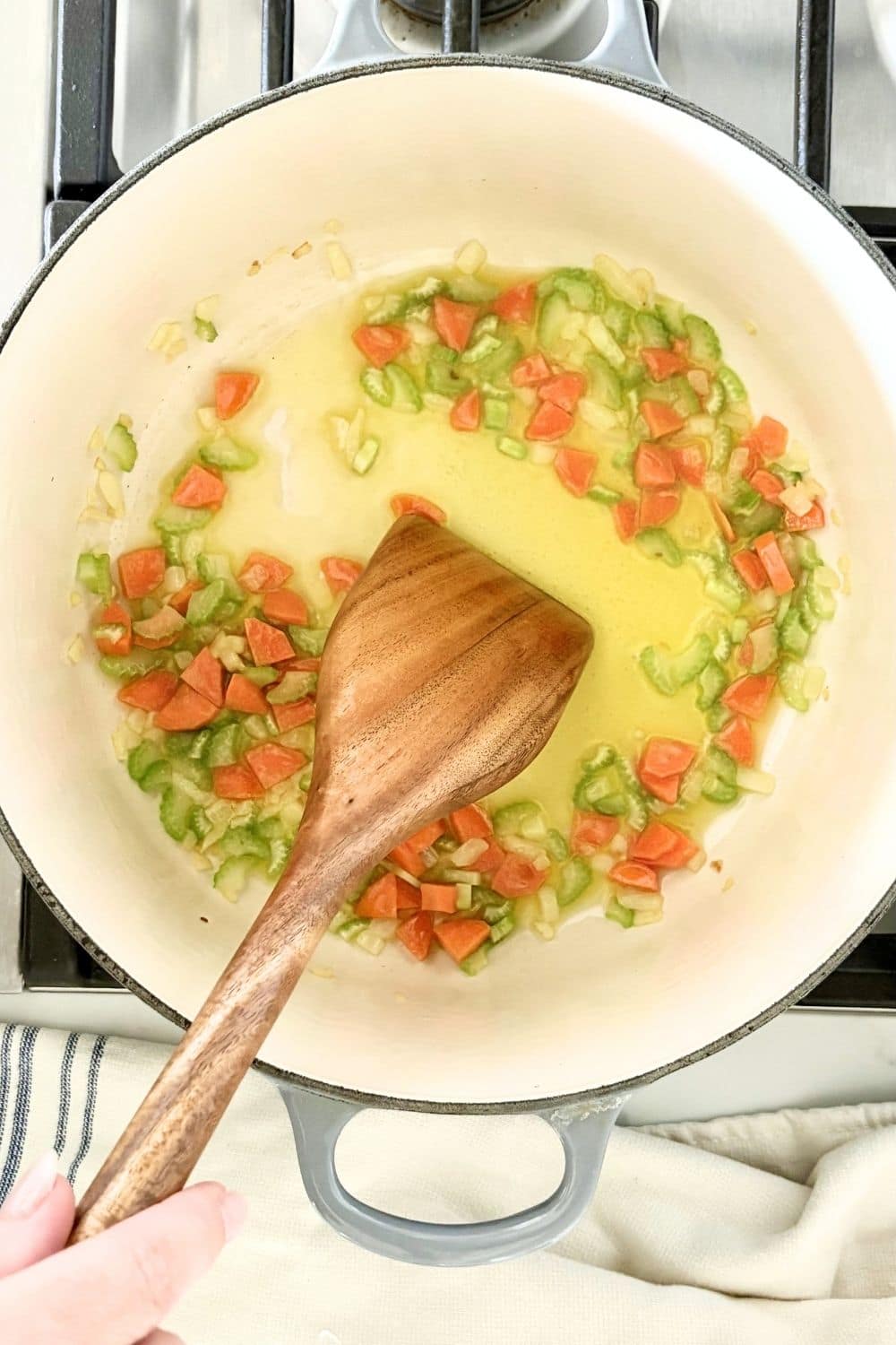 Chopped onion, carrot, and celery cooking in olive oil to make Italian soffritto