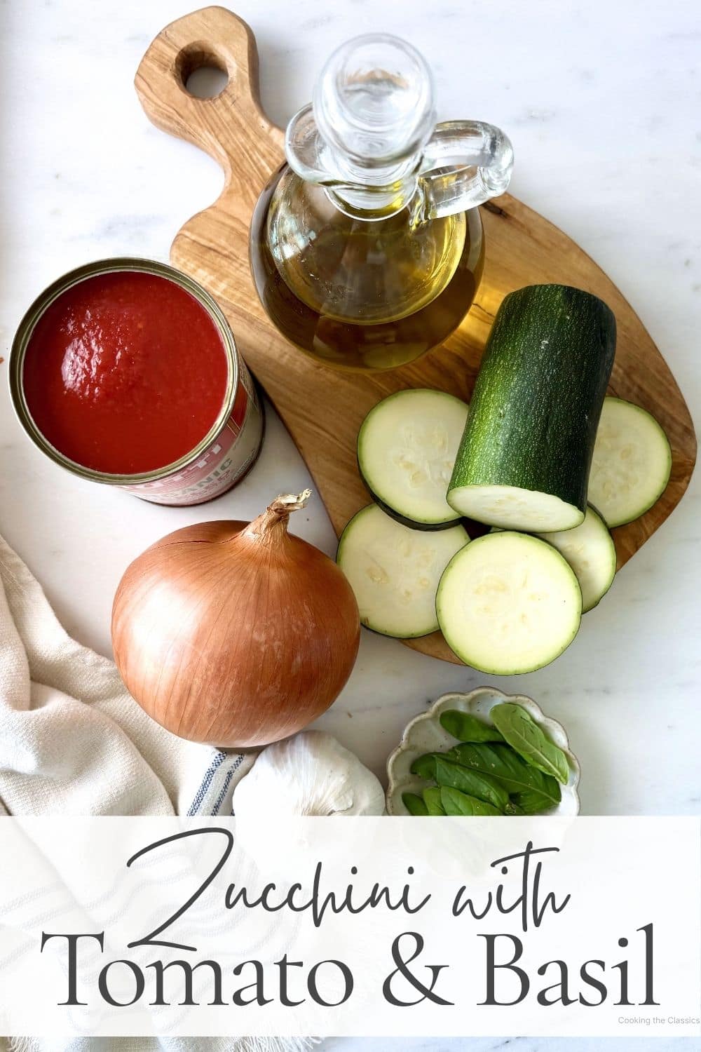 Ingredients for zucchini with tomato and basil including zucchini, canned tomatoes, onion, garlic, olive oil, and fresh basil