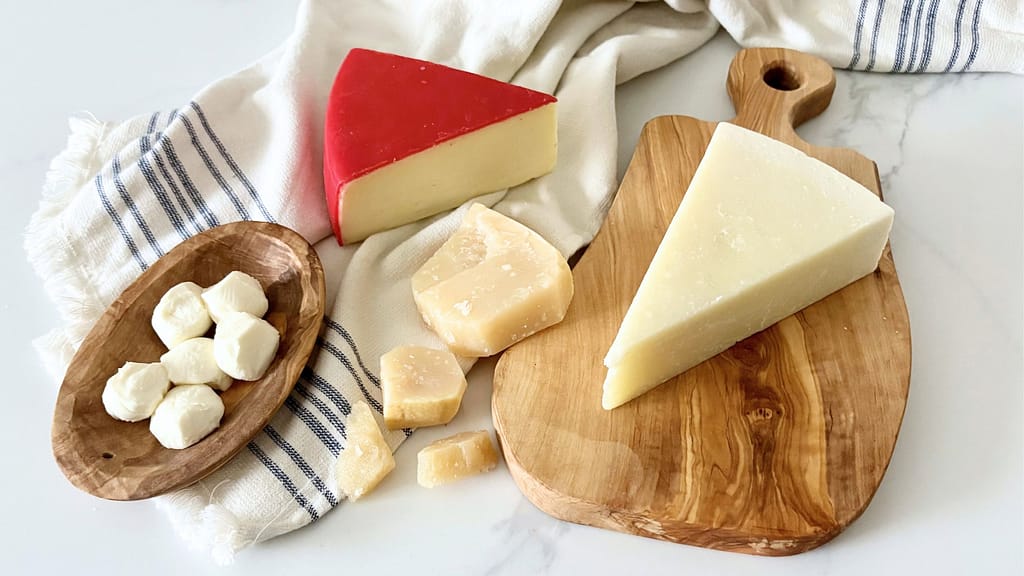 Assorted Italian cheeses including Parmigiano Reggiano, Pecorino Romano, mozzarella, and Fontina on wooden boards