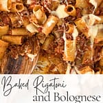 Close-up of baked rigatoni with Bolognese and melted cheese in a baking dish with a wooden spoon