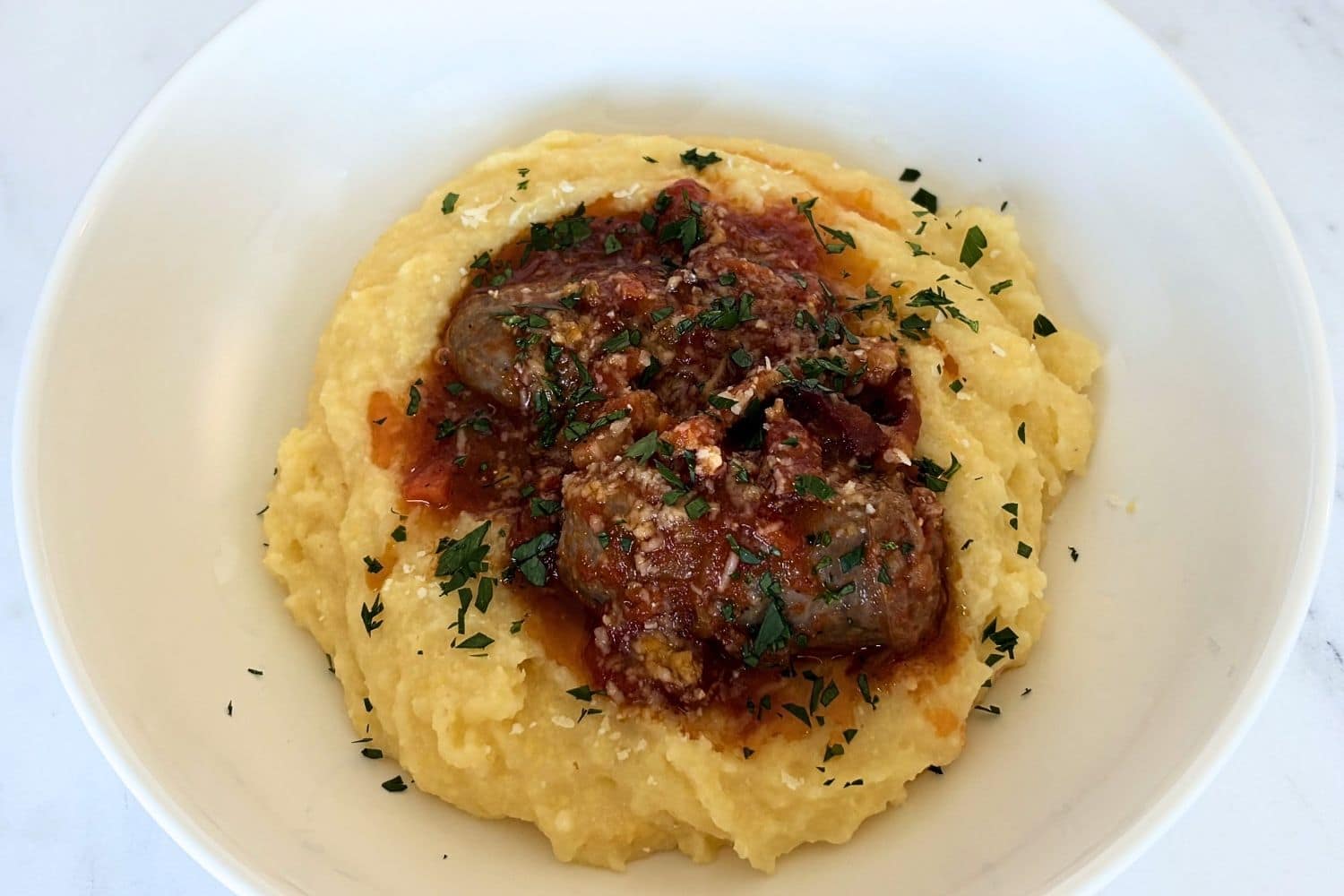 Marcella Hazan's Three Ingredient Tomato Sauce Soft polenta served with Italian sausage in tomato sauce and finished with parsley