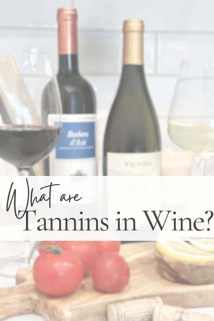 Wine guide graphic titled “What are Tannins in Wine?” featuring red and white wine bottles, wine glasses, tomatoes, and lemons on an olive wood board with a soft white text overlay.